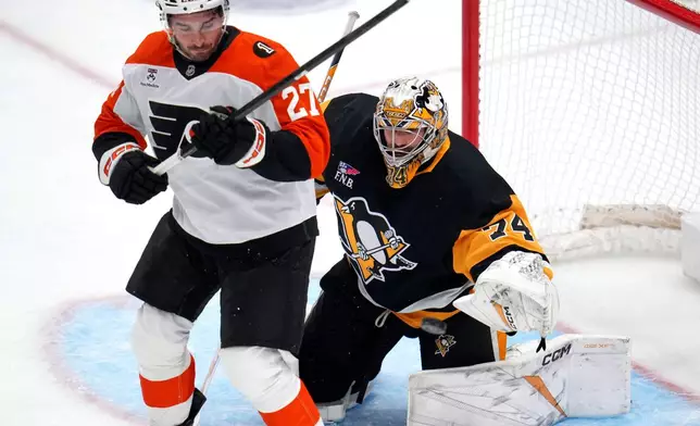 Philadelphia Flyers right wing Owen Tippett (74) blocks a shot while being screened by Philadelphia Flyers' Noah Cates (27) during the first period of an NHL hockey game in Pittsburgh, Saturday, March 7, 2026. (AP Photo/Gene J. Puskar)
