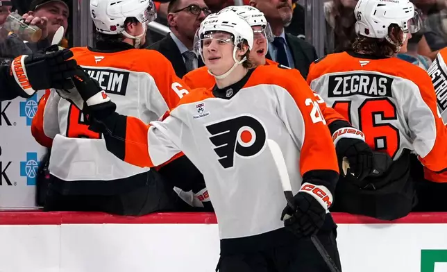 Philadelphia Flyers' Alex Bump, center, returns to the bench after scoring during the second period of an NHL hockey game against the Pittsburgh Penguins in Pittsburgh, Saturday, March 7, 2026. (AP Photo/Gene J. Puskar)
