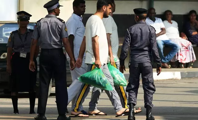 Two Iranian sailors, center, who were rescued from IRIS Dena warship by Sri Lanka's navy are escorted to a Judicial Medical Officer from the National Hospital, in Galle, Sri Lanka, Thursday, March 5, 2026. (AP Photo/Eranga Jayawardena)