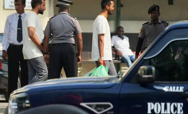 Iranian sailors, wearing t-shirts, who were rescued from IRIS Dena warship by Sri Lanka's navy, are escorted to a Judicial Medical Officer from the National Hospital, in Galle, Sri Lanka, Thursday, March 5, 2026. (AP Photo/Eranga Jayawardena)