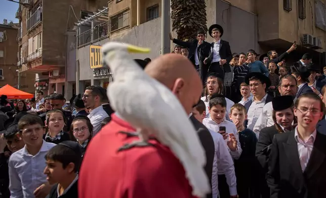 People gather outside an apartment building damaged by an Iranian missile strike in Bnei Brak, Israel, Sunday, March 15, 2026. (AP Photo/Oded Balilty)