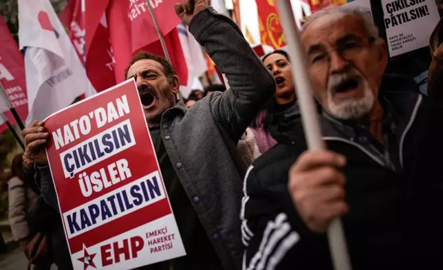 People shout slogans during an anti U.S. and Israeli rally outside the U.S. consulate in Istanbul, Turkey, Sunday, March 15, 2026. The sign reads in Turkish: "Leave NATO, close the bases." (AP Photo/Emrah Gurel)