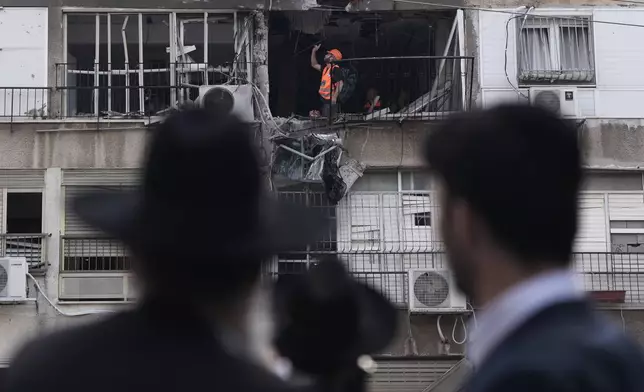 Home Front Command officer works at an apartment damaged after an Iranian strike in Bnei Brak, Israel, Sunday, March 15, 2026. (AP Photo/Oded Balilty)