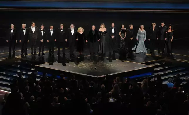 Michael McKean, from left, Christopher Guest, Jerry O'Connell, Will Wheaton, Fred Savage, Cary Elwes, Mandy Patinkin, Carol Kane, Billy Crystal, Meg Ryan, Kiefer Sutherland, Demi Moore, Kevin Pollak, Kathy Bates, Annette Bening, John Cusack, and Daphne Zuniga stand in tribute to Rob Reiner during the Oscars on Sunday, March 15, 2026, at the Dolby Theatre in Los Angeles. (AP Photo/Chris Pizzello)