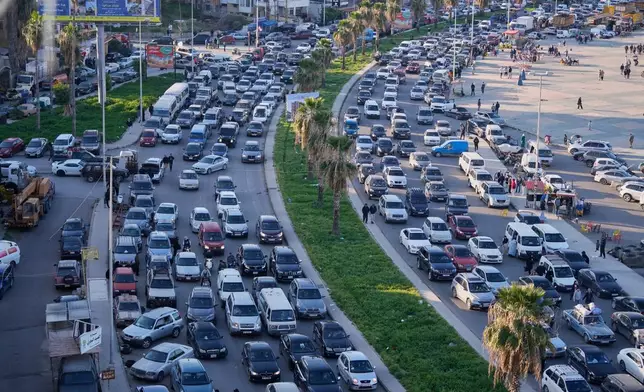 Displaced people fleeing Israeli strikes in southern Lebanon sit in traffic at a highway links to Beirut, in the southern port city of Sidon, Monday, March 2, 2026. (AP Photo/Mohammed Zaatari)