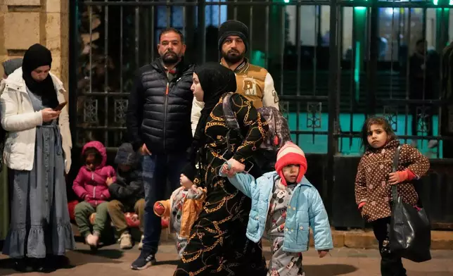 A displaced family fleeing Israeli strikes in southern Lebanon arrives in the southern port city of Sidon, early Monday, March 2, 2026. (AP Photo/Mohammed Zaatari)