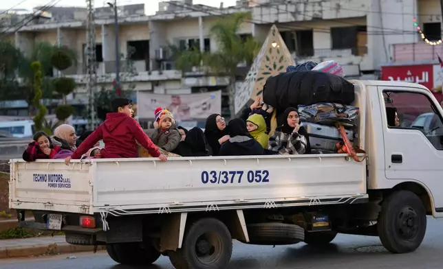 Displaced people fleeing Israeli airstrikes in southern Lebanon ride on a mini truck along a highway toward Beirut, in the southern port city of Sidon, Lebanon, Monday, March 2, 2026. (AP Photo/Mohammed Zaatari)