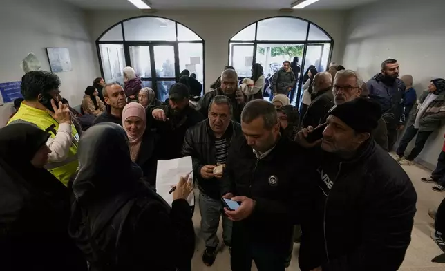 Displaced families fleeing Israeli airstrikes in southern Lebanon register their names as they arrive at a school turned into a shelter, in Beirut, Lebanon, Monday, March 2, 2026. (AP Photo/Bilal Hussein)
