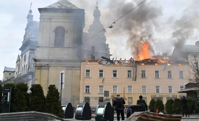 Fire and smoke raises above the city center following Russia's drone attack in Lviv, Ukraine, Tuesday, March 24, 2026. (AP Photo/Mykola Tys)