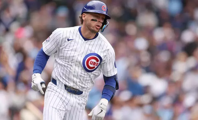 Chicago Cubs Nico Hoerner (2) runs to first after hitting a single during the fourth inning of a baseball game against the Washington Nationals on Sunday, March 29, 2026, in Chicago. (AP Photo/Geoff Stellfox)