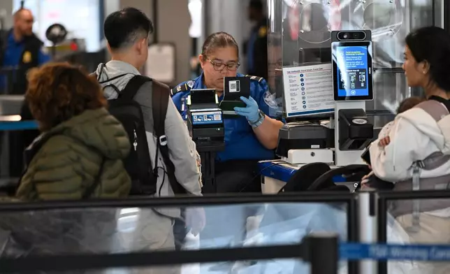 Passengers are screened by a TSA agent at O'Hare Airport in Chicago, Thursday, March 26, 2026. (AP Photo/Paul Beaty)