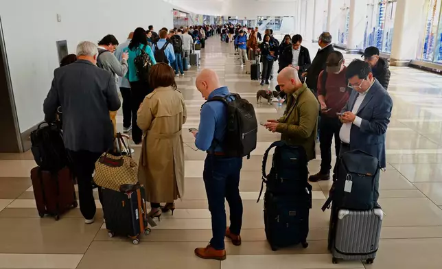 Passengers stand in the TSA pre check in line at LaGuardia Airport, Thursday, March 26, 2026, in East Elmhurst, N.Y. (AP Photo/Noah K. Murray)