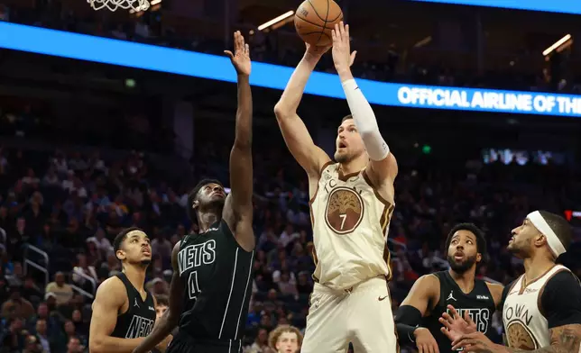 Golden State Warriors center Kristaps Porzingis (7) shoots against Brooklyn Nets guard Drake Powell (4) during the second half of an NBA basketball game in San Francisco, Wednesday, March 25, 2026. (AP Photo/Jed Jacobsohn)