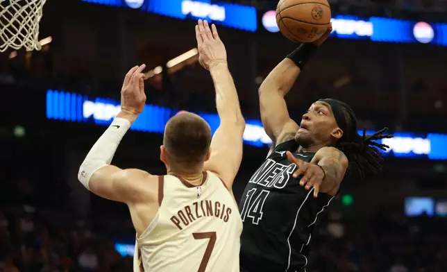 Brooklyn Nets guard Terance Mann (14) shoots against Golden State Warriors center Kristaps Porzingis (7) during the first half of an NBA basketball game in San Francisco, Wednesday, March 25, 2026. (AP Photo/Jed Jacobsohn)