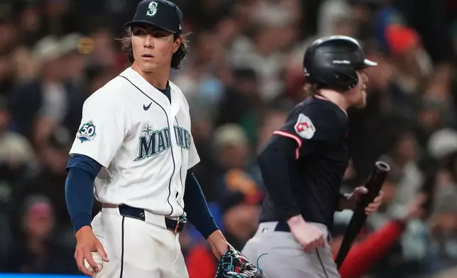 Seattle Mariners starting pitcher Bryan Woo reacts after allowing a run against the Cleveland Guardians during the sixth inning of a baseball game, Saturday, March 28, 2026, in Seattle. (AP Photo/Lindsey Wasson)