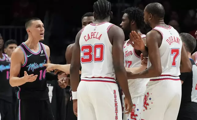 Miami Heat guard Tyler Herro (14) and Houston Rockets forward Kevin Durant (7) exchange words during the first half of an NBA basketball game, Saturday, Feb. 28, 2026, in Miami. (AP Photo/Lynne Sladky)