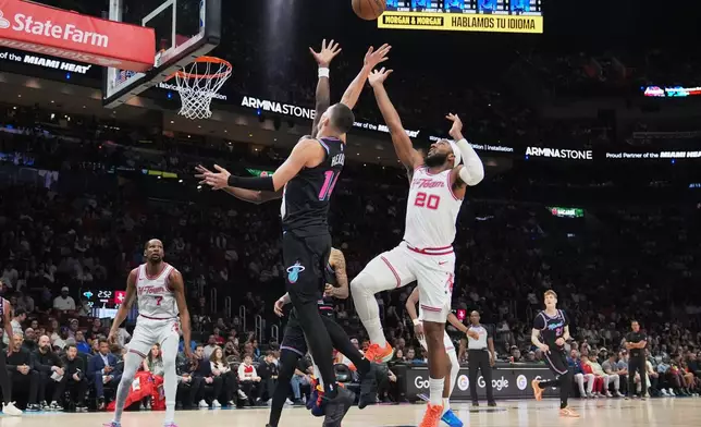 Miami Heat guard Tyler Herro (14) shoots over Houston Rockets guard Josh Okogie (20) during the first half of an NBA basketball game, Saturday, Feb. 28, 2026, in Miami. (AP Photo/Lynne Sladky)