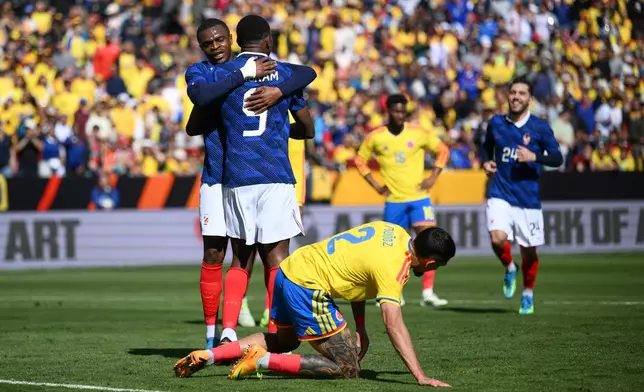 France forward Marcus Thuram (9) is embraced by Pierre Kalulu (5) after scoring his side's second goal during the international friendly soccer match between Colombia and France in Landover, Md., Sunday, March 29, 2026. (AP Photo/Nick Wass)