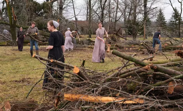 Volunteers work to clear branches felled by a storm a day earlier in Union City, Mich., Saturday, March 7, 2026. (AP Photo/Nam Y. Huh)