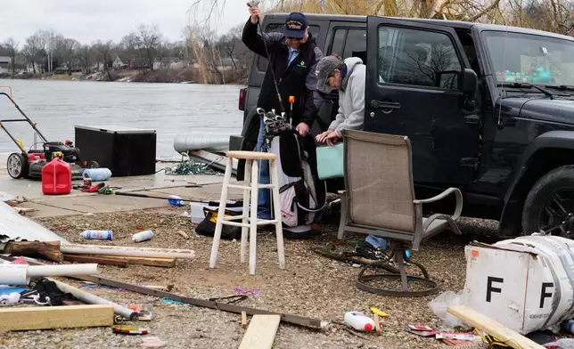 Home owners collect their personal belongings scattered amid debris in the aftermath of a powerful storm that ripped through the area a day earlier, in Union City Mich., Saturday, March 7, 2026. (AP Photo/Nam Y. Huh)