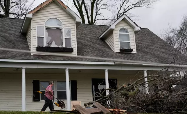 A volunteer works to clear up debris in the aftermath of a powerful storm that ripped through the area a day earlier, in Union City Mich., Saturday, March 7, 2026. (AP Photo/Nam Y. Huh)