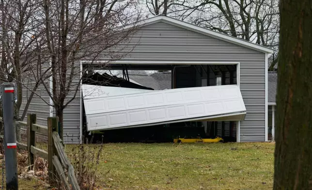 A storm-damaged garage door sits folded a day after a storm that whipped up a tornado ripped through the area, in Union City Mich., Saturday, March 7, 2026. (AP Photo/Nam Y. Huh)
