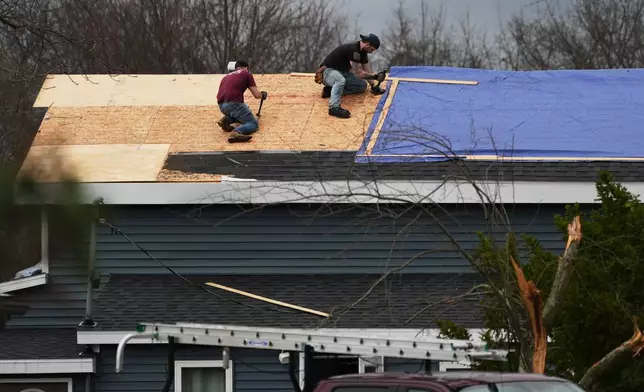 Volunteers work to repair a storm-damaged roof in the aftermath of a powerful storm that ripped through the area a day earlier, in Union City Mich., Saturday, March 7, 2026. (AP Photo/Nam Y. Huh)