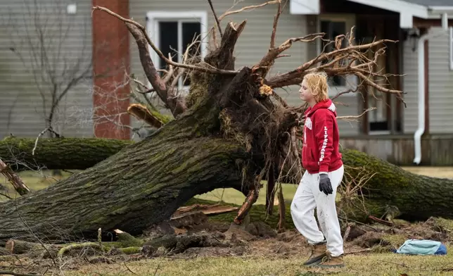 A volunteer works to clear debris a day after a storm whipped up a tornado through the area, in Union City Mich., Saturday, March 7, 2026. (AP Photo/Nam Y. Huh)
