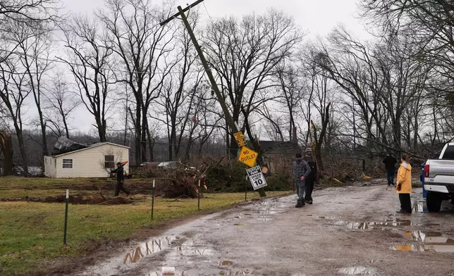 Volunteers look at the damage caused by a storm that whipped up a tornado through the area a day earlier, in Union City Mich., Saturday, March 7, 2026. (AP Photo/Nam Y. Huh)