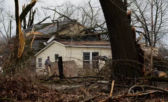 A volunteer works outside a home damaged by a storm that whipped up a tornado a day earlier, in Union City Mich., Saturday, March 7, 2026. (AP Photo/Nam Y. Huh)