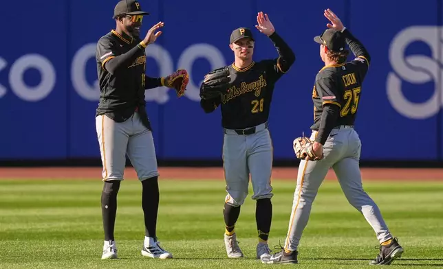 Pittsburgh Pirates outfielders Oneil Cruz, left, Jake Mangum, center, and Billy Cook celebrate after a baseball game against the New York Mets, Sunday, March 29, 2026, in New York. (AP Photo/Seth Wenig)