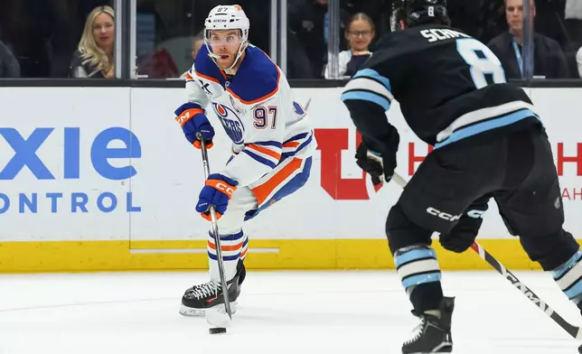 Edmonton Oilers center Connor McDavid (97) controls the puck against Utah Mammoth center Nick Schmaltz (8) during the first period of an NHL hockey game, Tuesday, March 24, 2026, in Salt Lake City. (AP Photo/Melissa Majchrzak)