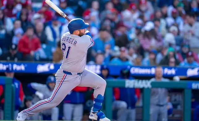 Texas Rangers' Jake Burger hits a two-run home run during the third inning of a baseball game against the Philadelphia Phillies, Saturday, March 28, 2026, in Philadelphia. (AP Photo/Chris Szagola)