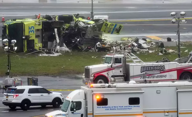 A Port Authority firetruck lays on its side just off the runway at LaGuardia Airport, Monday, March 23, 2026, after colliding with an Air Canada jet shortly after it landed late Sunday night in New York. (AP Photo/Seth Wenig)