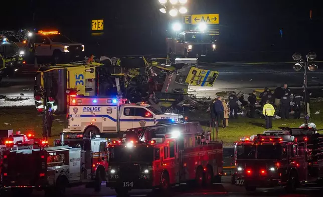 A Port Authority aircraft rescue and firefighting vehicle lays on its side off of runway 4 after colliding with an Air Canada jet after it landed at LaGuardia Airport, Monday, March 23, 2026, in New York. (AP Photo/Ryan Murphy)