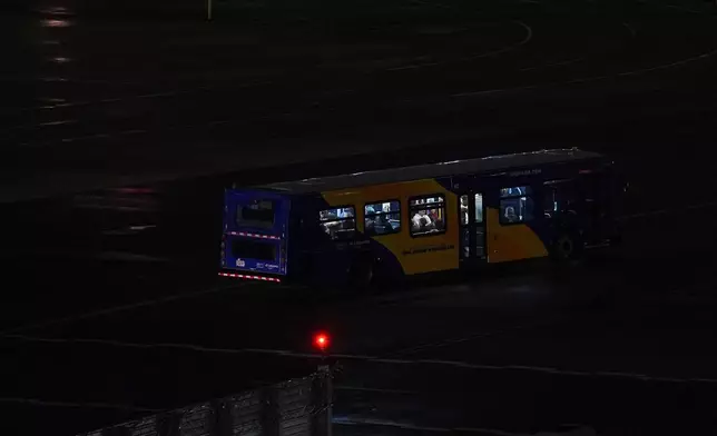 A Port Authority bus drives on the tarmac carrying people from the site where an Air Canada jet collided with a Port Authority flight rescue and firefighting truck at LaGuardia Airport, Monday, March 23, 2026, in New York. (AP Photo/Ryan Murphy)