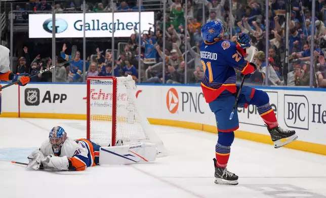 St. Louis Blues' Jimmy Snuggerud (21) celebrates after scoring past New York Islanders goaltender Ilya Sorokin, left, during the second period of an NHL hockey game Tuesday, March 10, 2026, in St. Louis. (AP Photo/Jeff Roberson)