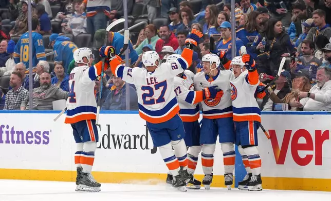 New York Islanders' Mathew Barzal, second from right, celebrates after scoring during overtime of an NHL hockey game to defeat the St. Louis Blues Tuesday, March 10, 2026, in St. Louis. (AP Photo/Jeff Roberson)