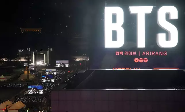 K-pop band BTS perform on the stage, left, during the comeback concert at Gwanghwamun Square in Seoul, South Korea, Saturday, March 21, 2026. (AP Photo/Lee Jin-man)