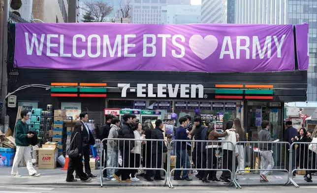 People pass by a banner for BTS ahead of a comeback concert of the K-pop band near Gwanghwamun Square in Seoul, South Korea, Friday, March 20, 2026. (AP Photo/Ahn Young-joon)