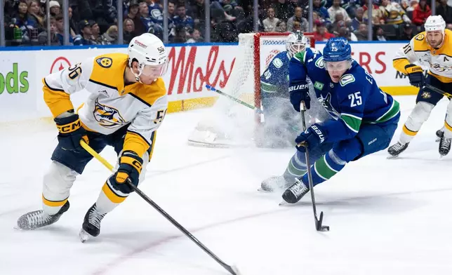 Vancouver Canucks' Elias Pettersson (25) skates with the puck as Nashville Predators' Erik Haula (56) watches during the second period of an NHL game in Vancouver, on Thursday, March 12, 2026. (Ethan Cairns/The Canadian Press via AP)