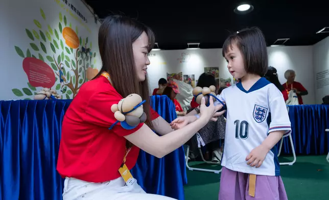Members of the Club’s CARE@HKJC Volunteer Team create balloon figures to bring joy to spectators at the fan village and pose for a photo with Raymond Tam, Executive Director of Corporate Affairs of The Hong Kong Jockey Club (photo 9, 6th right).