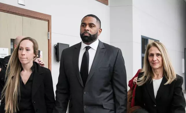 Former Michigan football coach Sherrone Moore arrives for a court hearing with his wife, Kelli Moore, left, and attorney Ellen Michaels, Friday, March 6 2026, at Washtenaw County 14A-1 District in Ann Arbor, Mich. (Jordyn Pair/Ann Arbor News via AP)