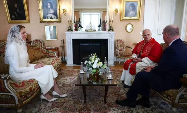 Princess Charlene of Monaco, left, and Prince Albert II of Monaco, right, meet Pope Leo XIV at the Prince's Palace during Leo XIV's one-day pastoral visit to the Principality of Monaco, Saturday, March 28, 2026. (Guglielmo Mangiapane/Pool Photo via AP)