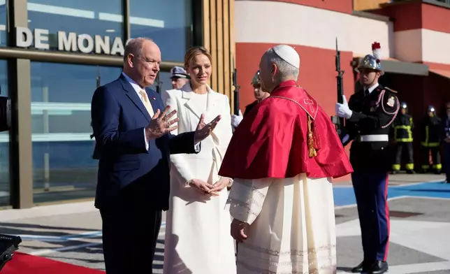Prince Albert II of Monaco and Princess Charlene of Monaco welcome Pope Leo XIV on the tarmac of Monaco Heliport in Monte Carlo, Monaco, Saturday, March 28, 2026. (AP Photo/Gregorio Borgia, Pool)