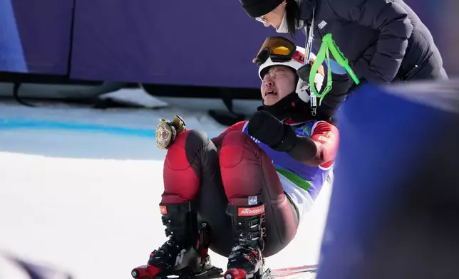 Mengqiu Zhang, of China, reacts after failing to finish the alpine skiing women's super-G standing final at the 2026 Winter Paralympics, in Cortina d'Ampezzo, Italy, Monday, March 9, 2026. (AP Photo/Emilio Morenatti)