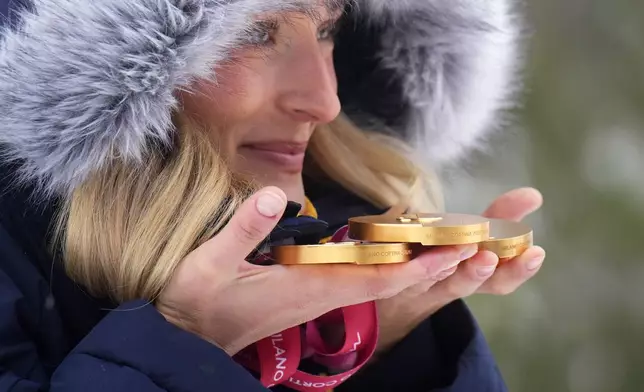 Ebba Aarsjoe, of Sweden, poses for photos with her three alpine skiing gold medals, at the 2026 Winter Paralympics, in Cortina d'Ampezzo, Italy, Sunday, March 15, 2026. (AP Photo/Emilio Morenatti)