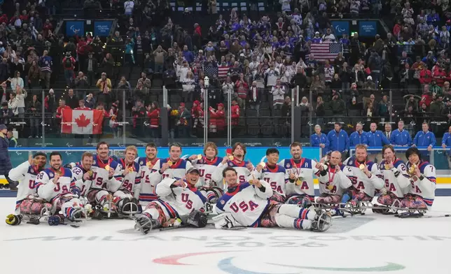 Players of the United States celebrate on the podium after winning the gold medal at the ice hockey of the 2026 Winter Paralympics, in Milan, Italy, Sunday, March 15, 2026. (AP Photo/Luca Bruno)