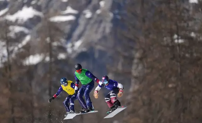 Zach Miller, of the United States, from left, Keith Gabel, of the United States, and Alex Massie, of Canada, compete in a men's snowboard cross SB-LL2 semifinal at the 2026 Winter Paralympics, in Cortina d'Ampezzo, Italy, Sunday, March 8, 2026. (AP Photo/Evgeniy Maloletka