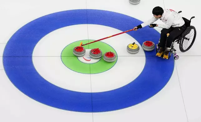 Jinqiao Yang, of China, competes during wheelchair curling mixed doubles round robin session against Italy at the 2026 Winter Paralympics, in Cortina d'Ampezzo, Italy, Thursday, March 5, 2026. (AP Photo/Evgeniy Maloletka)